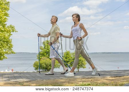 Young Couple Hiking In The Nature Nordic Walking