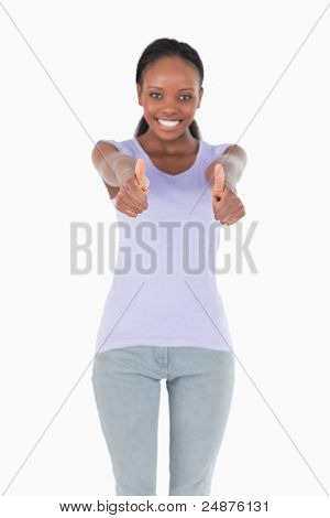 Close up of thumbs up essendo dato da donna sorridente su sfondo bianco