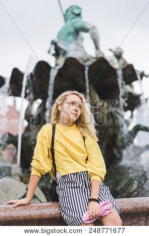 Young Woman Looking Away In Front Of Neptunbrunne In Berlin, Germany