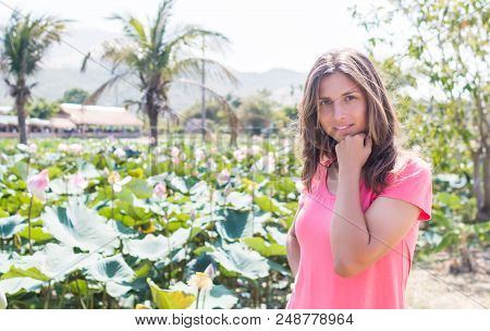 The Young Girl Stay In The Lotus Pond And Smile.