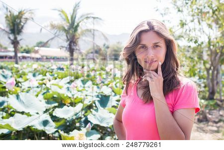 The Young Girl Stay In The Lotus Pond And Smile.