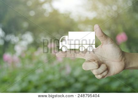 Truck Flat Icon On Finger Over Blur Pink Flower And Tree, Business Transportation Service Concept