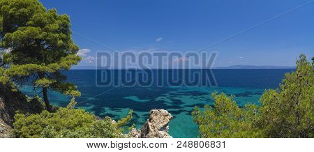 Beautiful Panorama With The Mediterranean Sea In Greece. Crystal And Colorful Water, Rocks, Vegetati