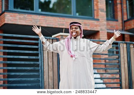 Middle Eastern Arab Man Posed On Street Against Modern Building Shows Tongue.