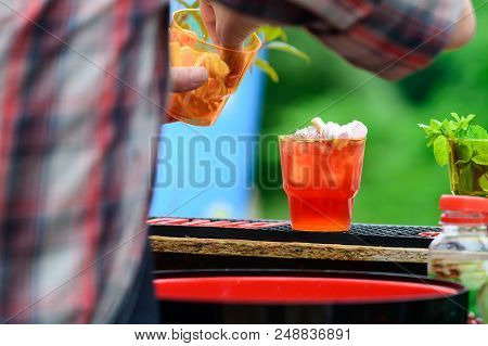 Selective Focus On Cold Fresh Cocktails In Glasses With Straw On Wooden Board. Process Of Preparing 