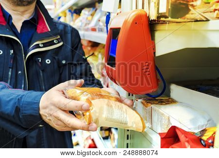 A Man Checking The Price Of Bread On The Scanner At The Grocery Store.target Self Price Scanner Lets