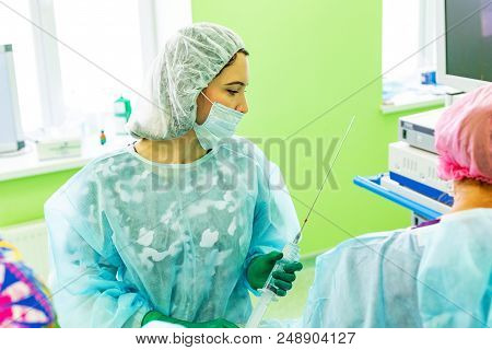 Cosmetic Liposuction Surgery In Actual Operating Room Setting Showing Surgeon Hands And Cannula