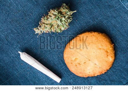 Cookies With Cannabis And Buds Of Marijuana On Table Rolled Joint . A Can Of Cannabis Buds Concept O