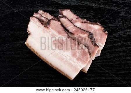 Group Of Three Slices Of English Bacon Flatlay On Black Wood