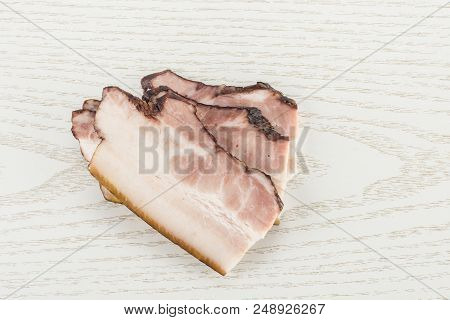 Group Of Three Slices Of English Bacon Flatlay On Grey Wood
