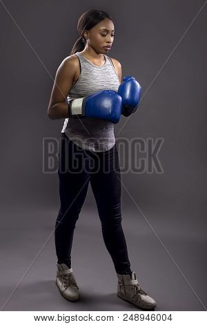Black Female Wearing Boxing Gloves Training Or Exercising.  She Is Posing With Punches And Depicts F