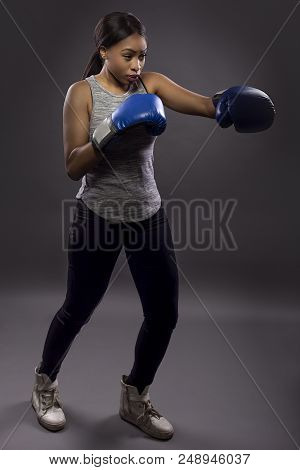Black Female Wearing Boxing Gloves Training Or Exercising.  She Is Posing With Punches And Depicts F