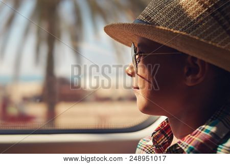 Cute Boy In Checkered Shirt Travelling By Train And Looking Into The Window While Passing Trough Sea