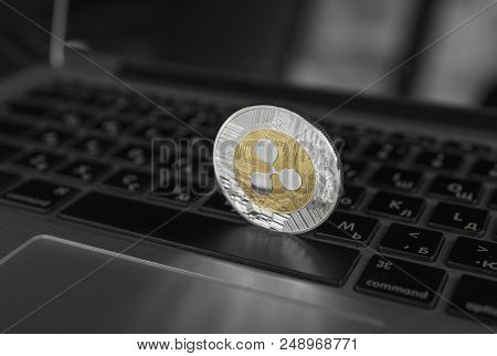 Silver Gold Ripple Coin On A Laptop Keyboard Closeup. Blockchain Mining. Digital Money And Virtual C