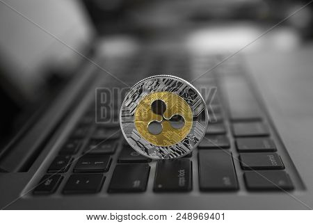 Silver Gold Ripple Coin On A Laptop Keyboard Closeup. Blockchain Mining. Digital Money And Virtual C