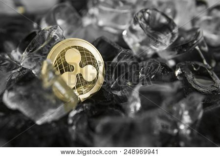 Gold Ripple Coin On Ice Background. The Concept Of The Exchange In Winter. Freeze. Blockchain Mining
