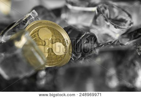 Gold Ripple Coin On Ice Background. The Concept Of The Exchange In Winter. Freeze. Blockchain Mining