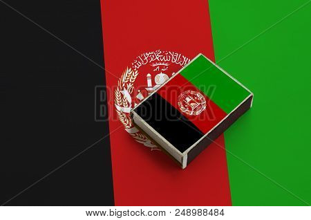 Afghanistan Flag Is Pictured On A Matchbox That Lies On A Large Flag.