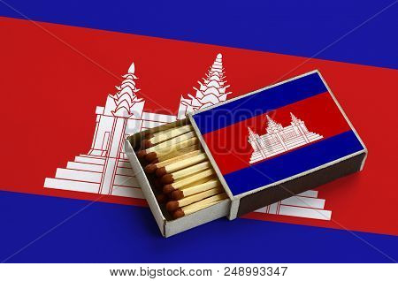 Cambodia Flag  Is Shown In An Open Matchbox, Which Is Filled With Matches And Lies On A Large Flag.