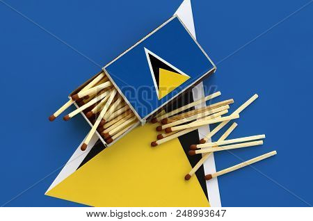 Saint Lucia Flag  Is Shown On An Open Matchbox, From Which Several Matches Fall And Lies On A Large 