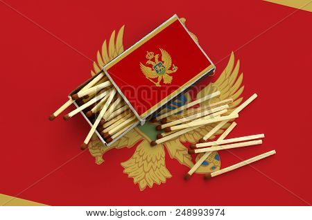 Montenegro Flag  Is Shown On An Open Matchbox, From Which Several Matches Fall And Lies On A Large F