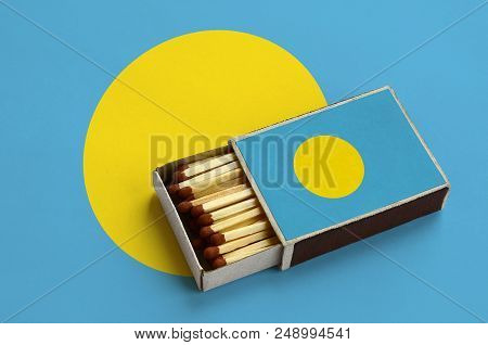 Palau Flag  Is Shown In An Open Matchbox, Which Is Filled With Matches And Lies On A Large Flag.