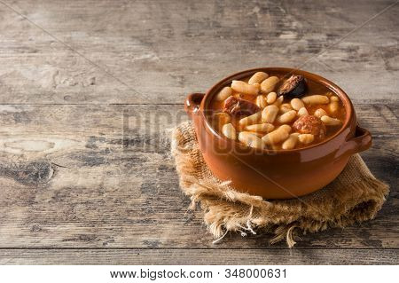 Typical Spanish Fabada Asturiana On Wooden Table. Copy Space