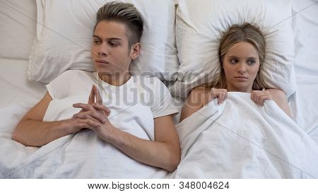 Embarrassed And Shy Young Couple Before First Intimacy In Bed, Inexperience