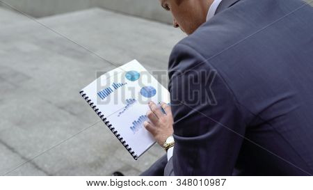 Pensive Financial Consultant Examining Business Graphs, Company Going Bankrupt