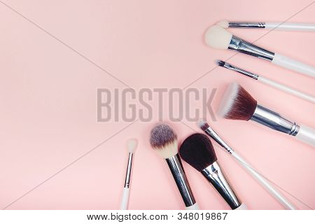 Set Makeup Brushes On Pink Color Background. Top View Point, Flat Lay
