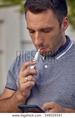 Electronic Cigarettes, Cigarette Technology. Tobacco Iqos System. Close-up Of A Man Smoking An Elect