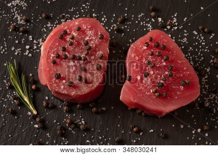Fresh Raw Tuna Fillet For Steak On Cutting Board With Lemon Lime Salt Pepper And Spices On Dark Blac
