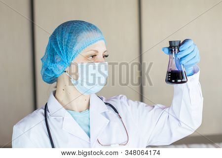 Novel Coronavirus (2019-ncov). Nurse Wearing Respirator Mask Holding Vaccine For The New Rapidly Spr