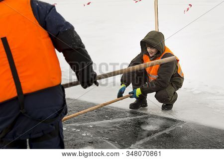 Worker Rafts Ice Blocks Along A Canal Carved In A Frozen Lake