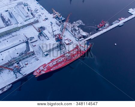 Commercial North Arctic Port Is Loading Containers Onto Cargo Tanker Ship. Concept Logistics And Del