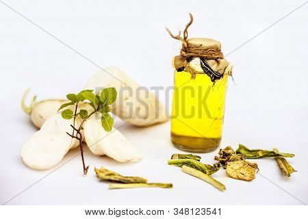 Freshly Sliced Daikon Radish Or White Radish Along With Its Seed Oil In A Glass Bottle Isolated On W