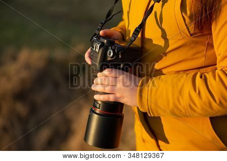 Young Woman Photographer With Professional Camer In Hand During Sunset