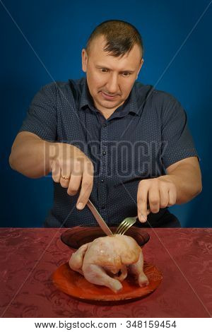 Studio Portrait Of The Hungry Person On A Blue Background. Wants Will Regale On Poultry. Gluttony An