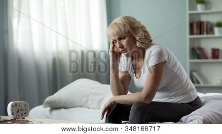 Adult Female Sitting Bed And Suffering From Migraine, Health Problem, Menopause