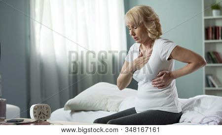 Middle-age Lady Touching Her Chest, Suffering From Heart Attack At Home, Disease