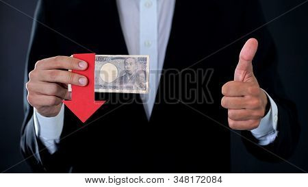 Financial Expert With Japanese Yen Banknotes Showing Thumbs Up And Down, Falling