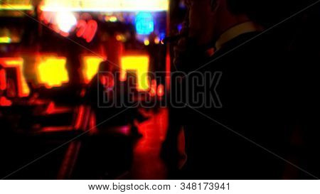 Young Businessman Smoking Cigar At Nightclub Party, Enjoying Evening Alone