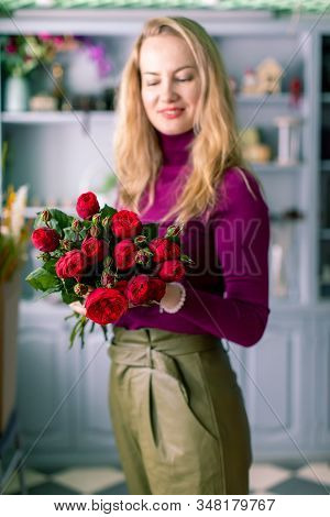Female Florist Holding Bouquet Of Red Roses. On Valentines Day Holiday