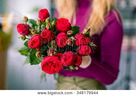 Female Florist Holding Bouquet Of Red Roses. On Valentines Day Holiday