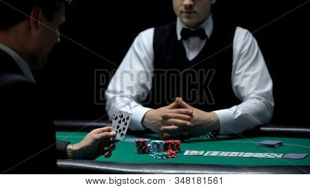 Overconfident Businessman Having Bad Hand Combination But Making Bet At Poker