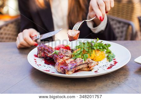 Woman Eat Healthy Lunch In Restaurant. Grilled Meat Steak With Cranberry Sauce, Glazed Peaches And A