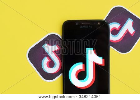 Tiktok Logo On Samsung Smartphone Screen On Yellow Background. Tiktok Is A Popular Video-sharing Soc