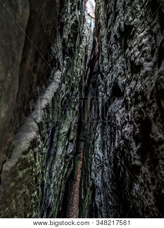 Narrow tourist path inside megalithic rock formations within Szczeliniec sanstone ravine, Table Mountain National Park, Poland