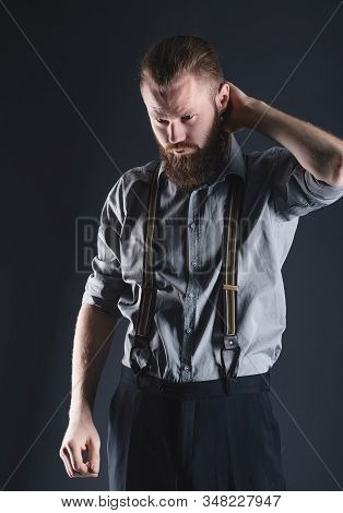 Young, Handsome Man With A Beard Posing On A Black Background In The Studio.