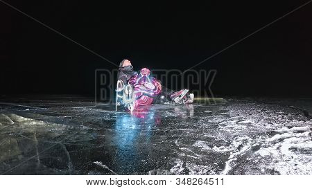 Young Loving Couple Skating At Ice Rink At Night. Man And Woman Kiss Hug Have Fun Learn To Skate. Ma